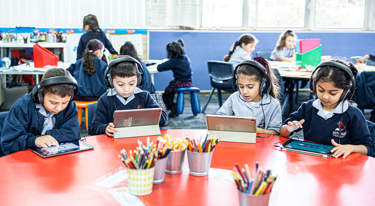 Sacred Heart Catholic Primary School Westmead students sitting at desk on iPads