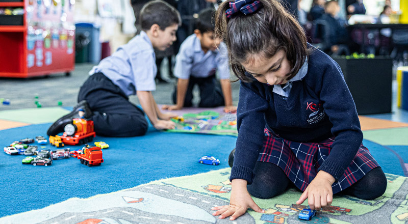 Sacred Heart Catholic Primary School Westmead student playing with toy cars on rug