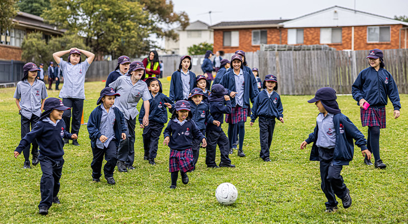Sacred Heart Catholic Primary School Westmead students running on the lawn