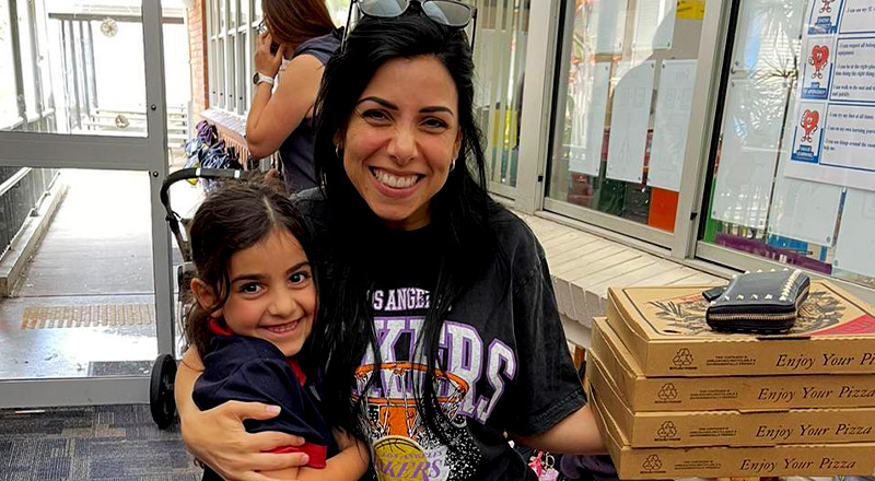 Sacred Heart Catholic Primary School Westmead parent holding child and pizza
