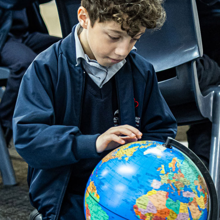 Sacred Heart Catholic Primary School Westmead student looking at globe
