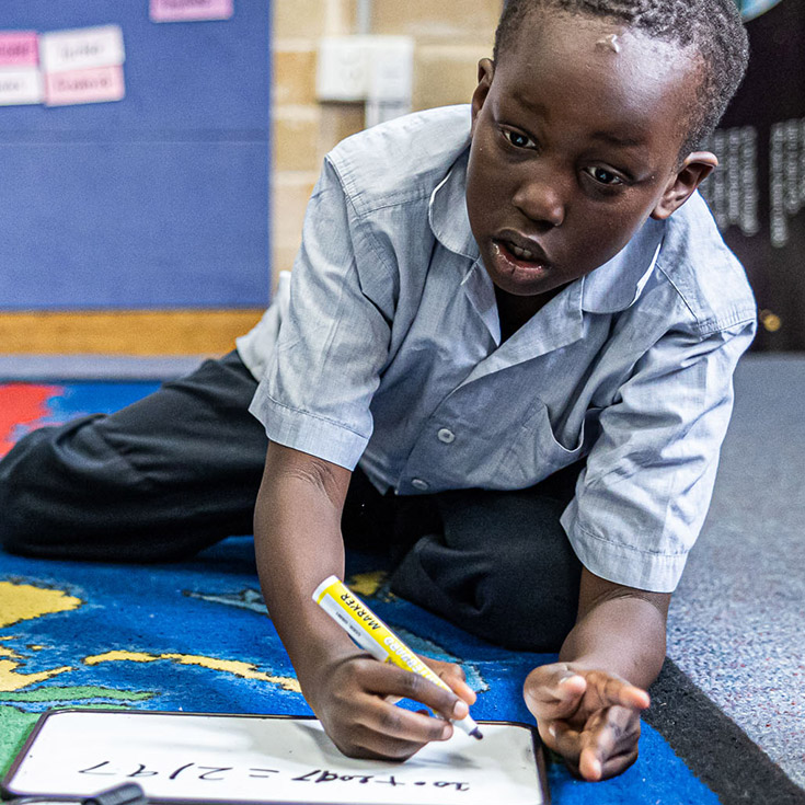 Sacred Heart Catholic Primary School Westmead student learning on rug